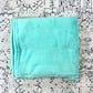 Plush teal blanket, folded.